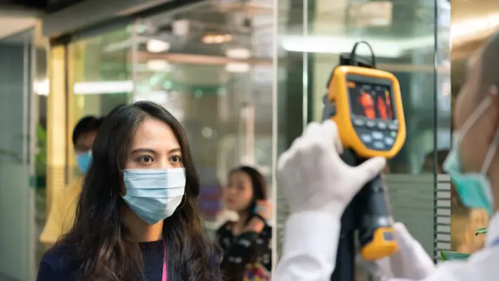 People waiting for temperature check by thermoscan