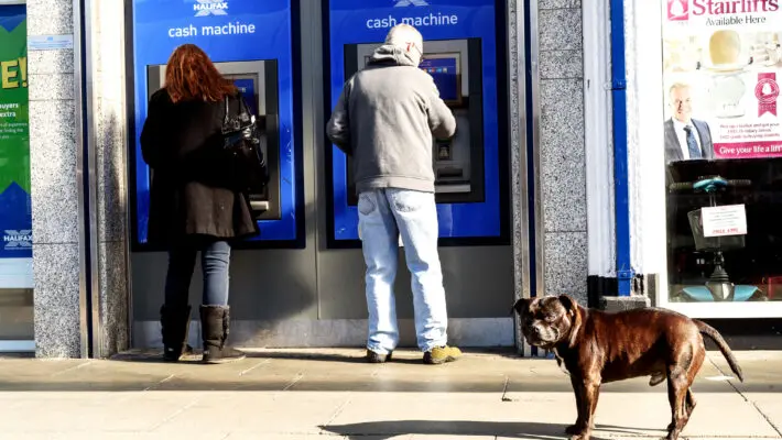 People at Cashpoint and a Dog