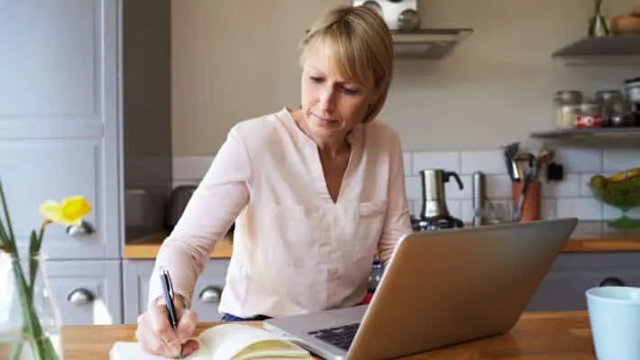 Woman Working From Home On Laptop In Modern Apartment