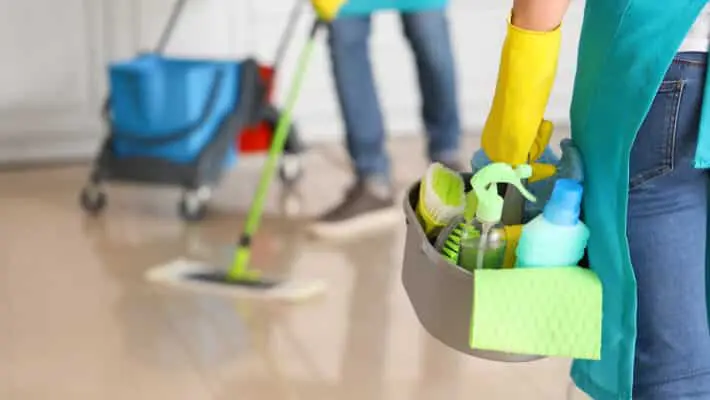 Female,Janitor,With,Cleaning,Supplies,In,Kitchen