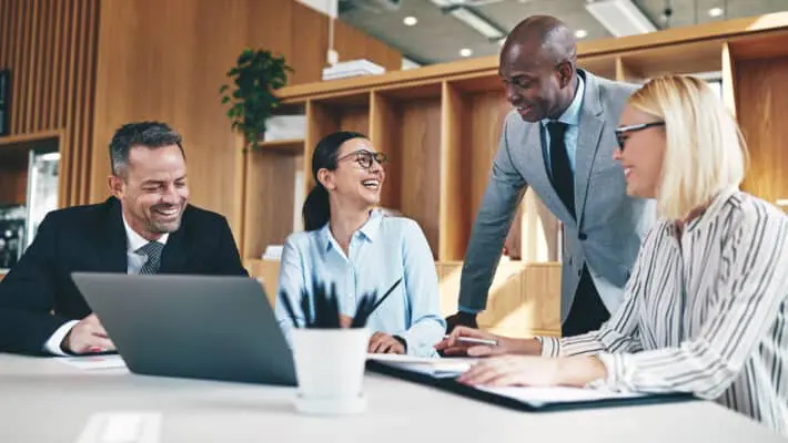 Group of diverse businesspeople laughing together during an offi