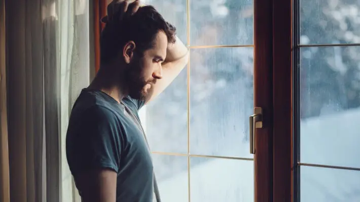 Young,Sad,Mad,Sitting,By,The,Window,In,Regret