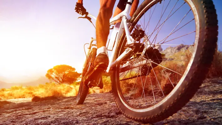 Low,Angle,View,Of,Cyclist,Riding,Mountain,Bike,On,Rocky