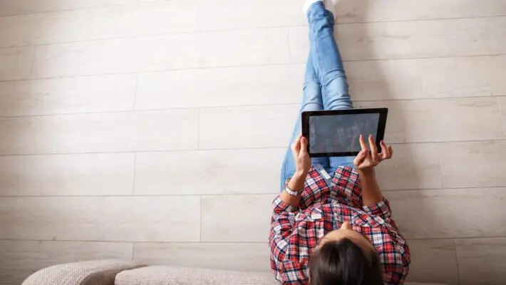 Young,Woman,Sitting,On,Floor,And,Using,Notebook.view,From,Above.