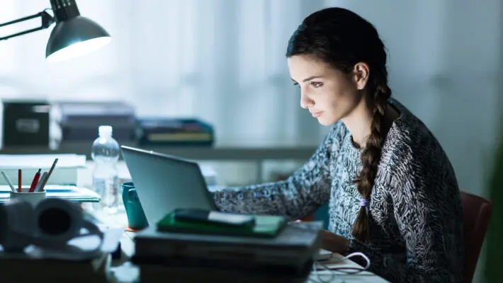 Pretty,Young,Student,Sitting,At,Desk,And,Doing,Her,Homework,