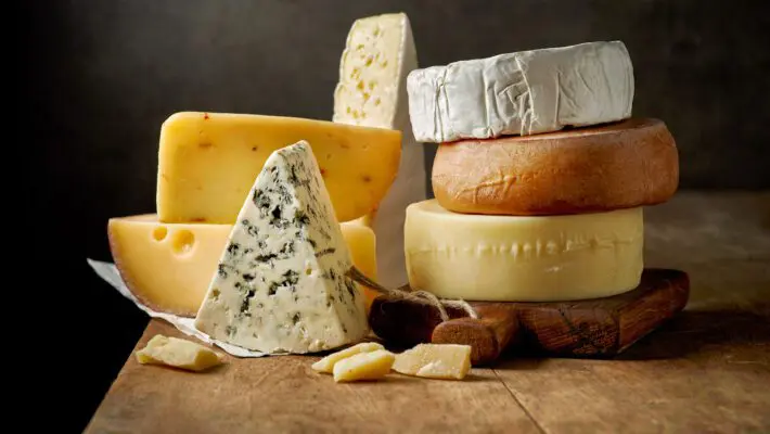 Various,Types,Of,Cheese,On,Rustic,Wooden,Table