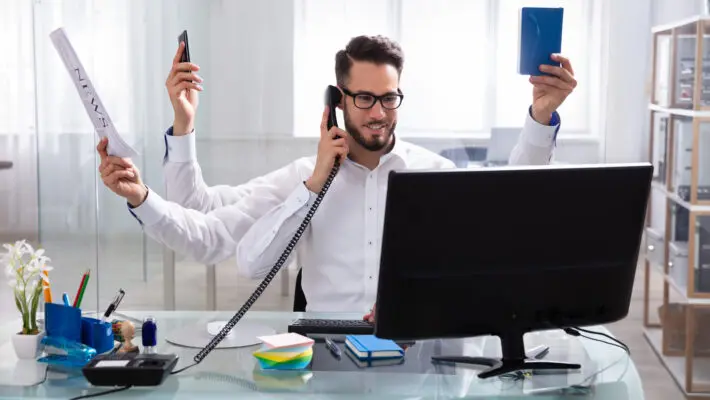 Smiling,Young,Businessman,Doing,Multitasking,Work,At,Workplace