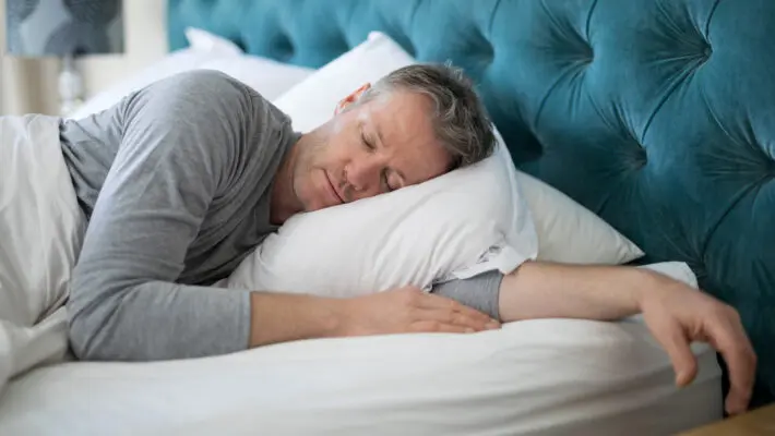 Man,Sleeping,On,Bed,In,Bedroom,At,Home