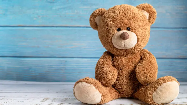 Cute,Teddy,Bear,With,Copy,Space,On,Blue,Color,Wood