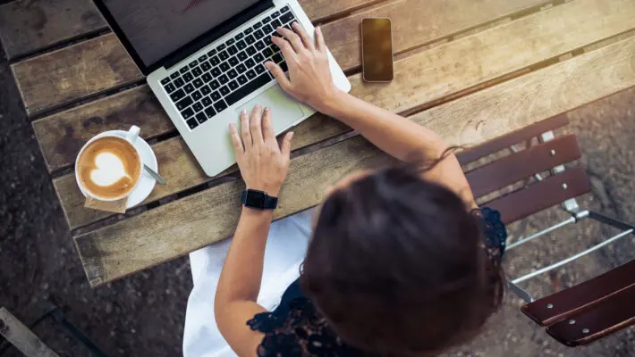 Top,View,Of,Female,Using,Her,Laptop,At,A,Cafe.