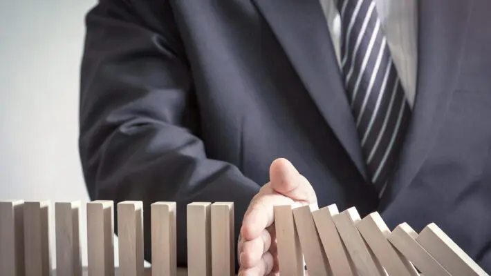 Management,Concept:,Manager,Hand,Stopping,The,Domino,Effect,On,Office