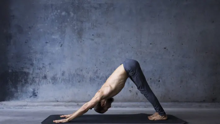 Young,Man,Practicing,Yoga,In,A,Urban,Background