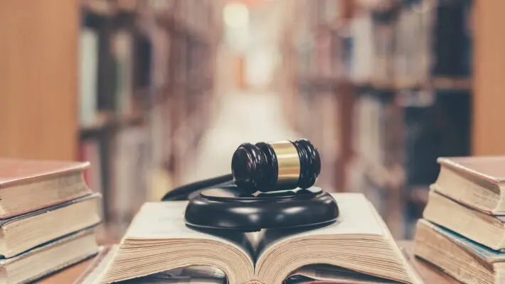 Old,Book,In,Library,With,Judge,Gavel,On,Open,Law