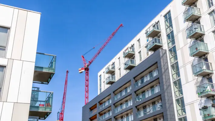 Facade,Of,A,Modern,Flat,With,Building,Cranes,In,The
