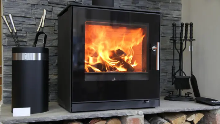 Black,Modern,Looking,Wood,Burning,Stove,With,Logs,Underneath