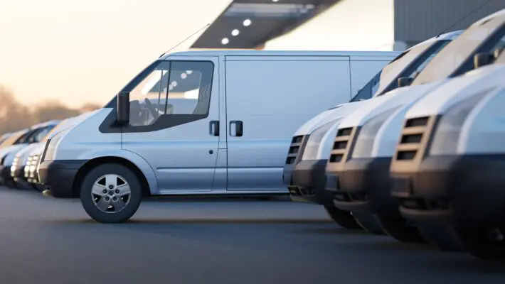 Delivery,Vans,Standing,Out,From,A,Fleet,Of,White,Vans.