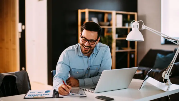 Young,Business,Man,Working,At,Home,With,Laptop,And,Papers
