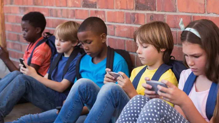 Cute,Pupils,Using,Mobile,Phone,At,The,Elementary,School