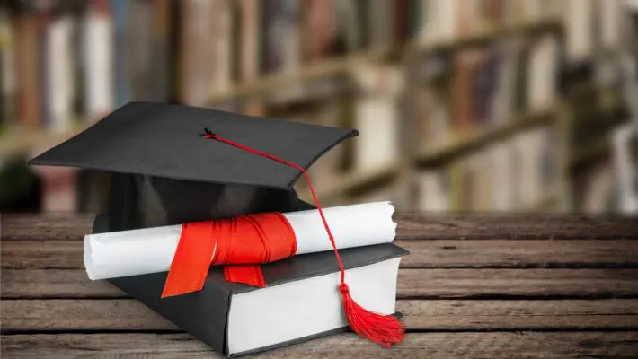 Graduation,Mortarboard,On,Book,On,Background