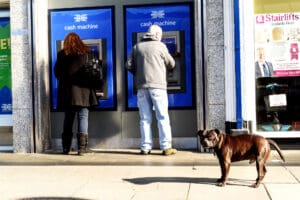 People at Cashpoint and a Dog