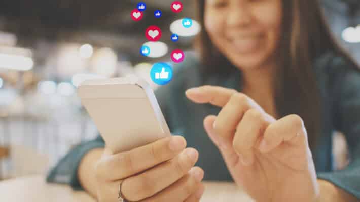 Social network sharing and commenting in the online community. Woman hand holding smartphone and using application social media
